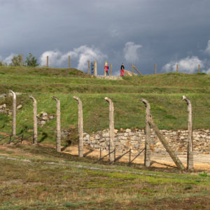 The people are at or near the rim of the stone quarry of the concentration camp.